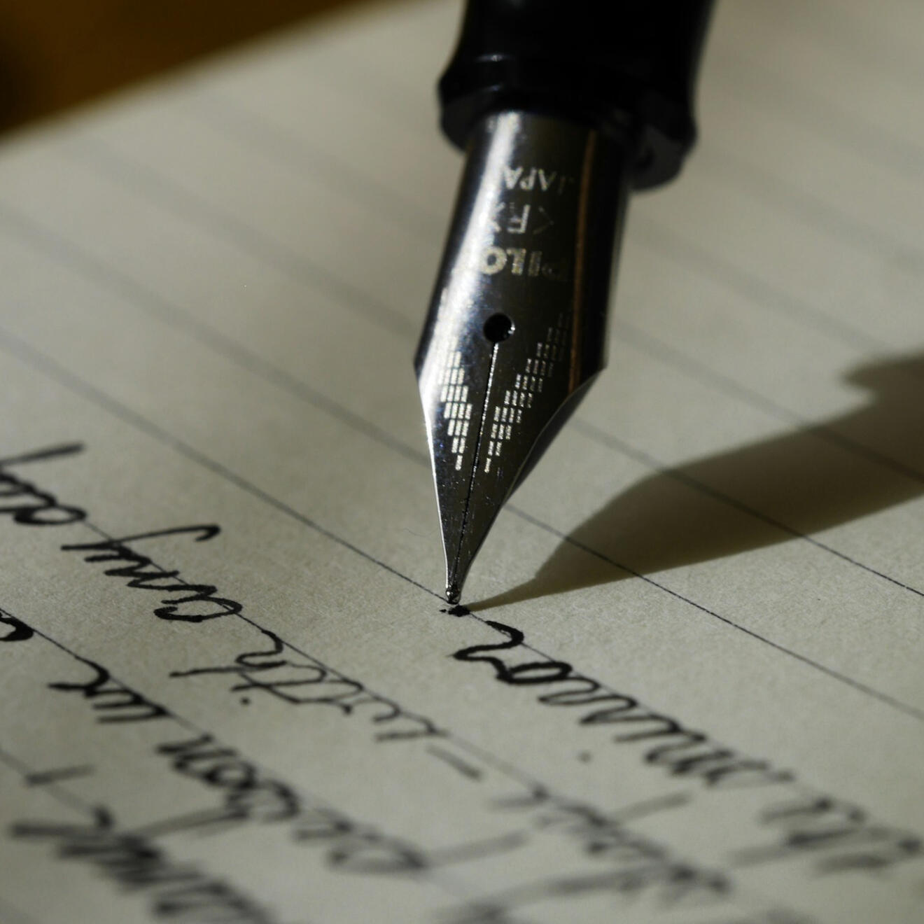 Website Messaging Close-up of a fountain pen writing on a notebook.