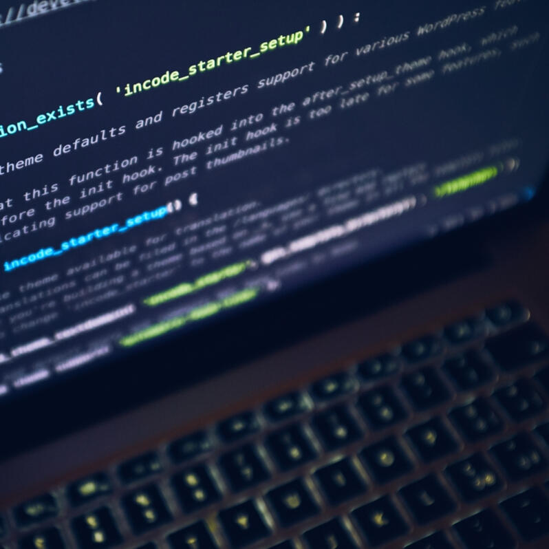 Build & Launch Laptop displaying source code on the screen during website development.